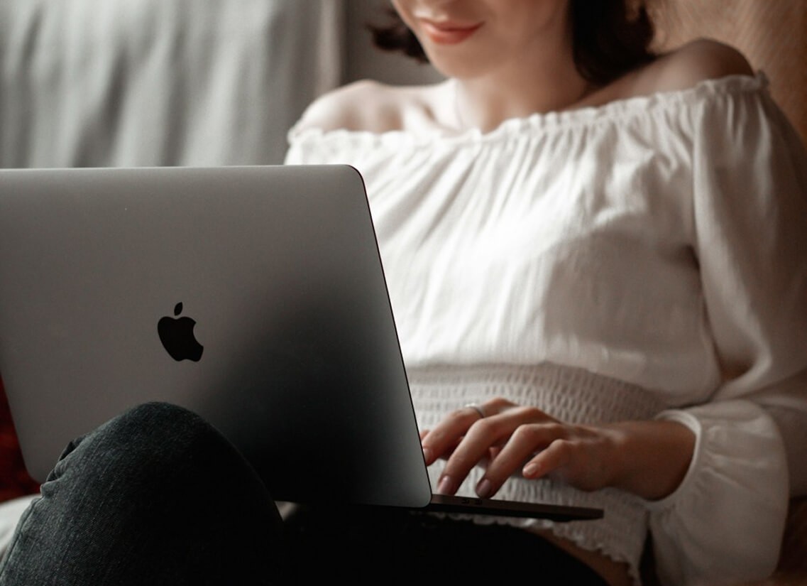 Person in a white off-shoulder top using a MacBook laptop, with text overlay 'What's new in digital?' and the Producer Development® logo in the top corner.